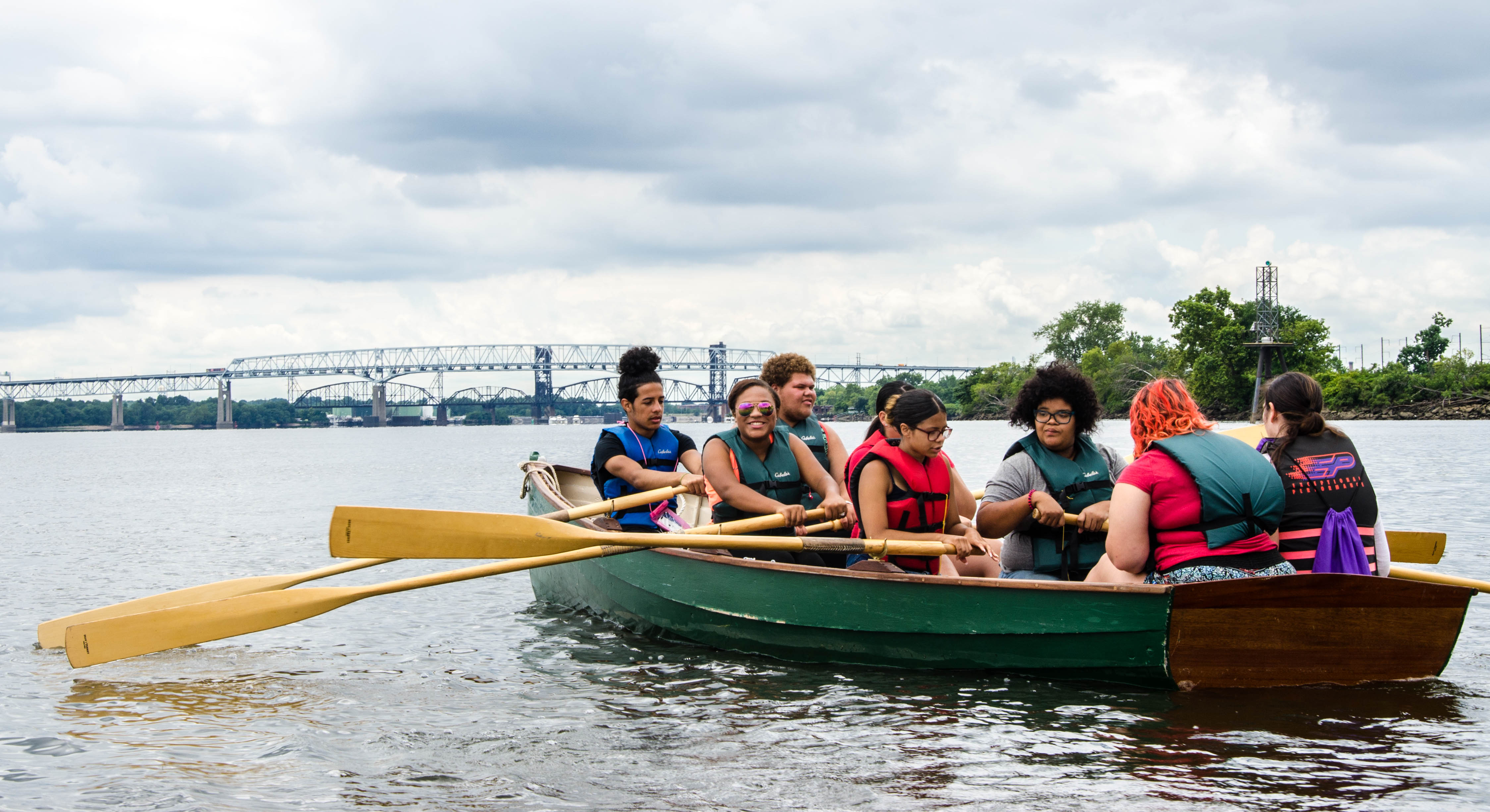 Photo: Youth in a canoe rowing together on a river.