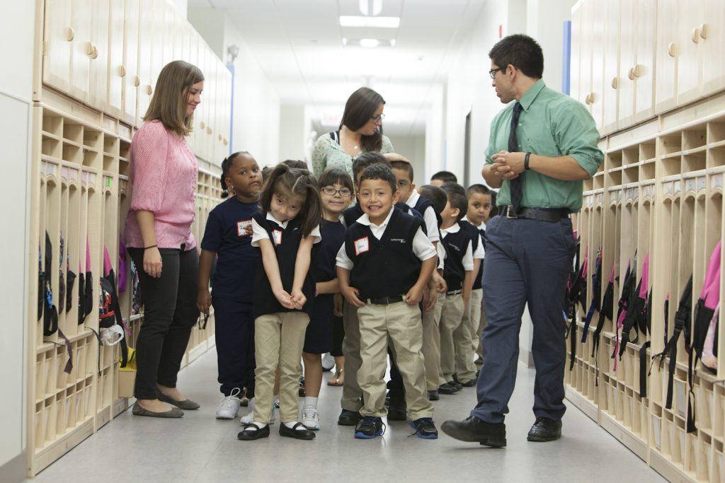 Photo: children at Christopher House walk down hallway with instructors.