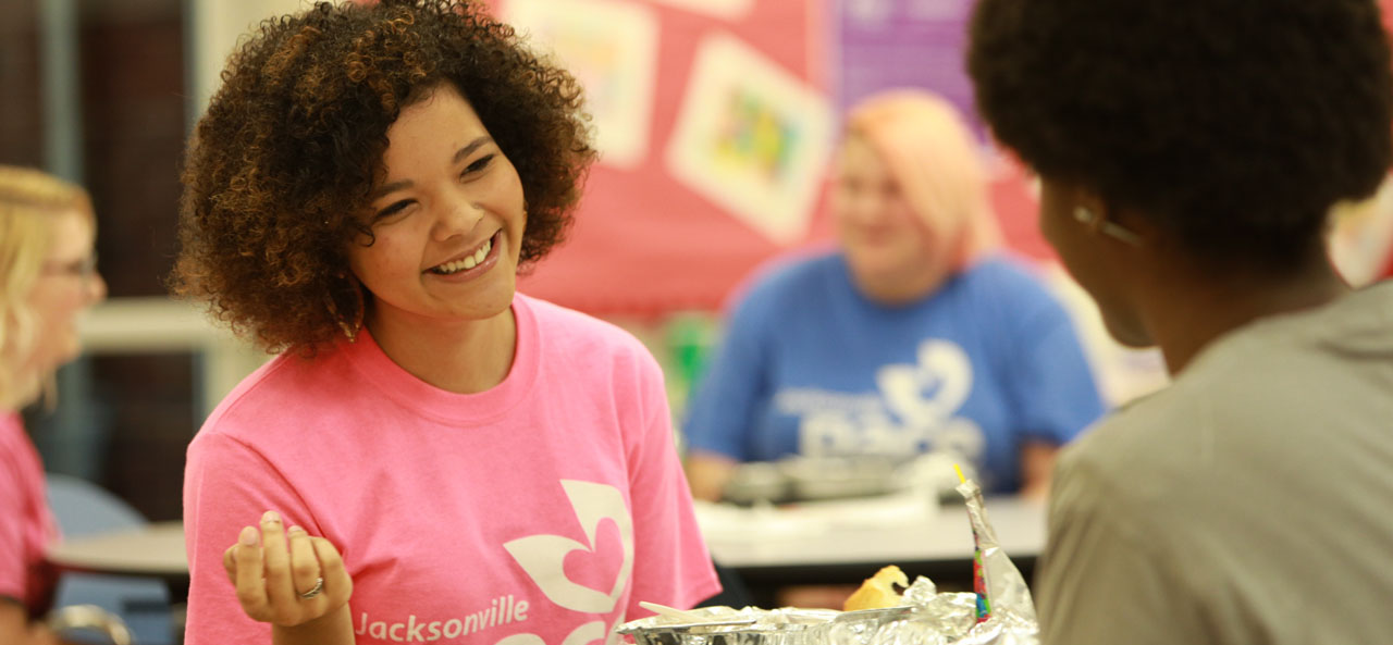 Photo: Young girl wearing PACE t-shirt and smiling.