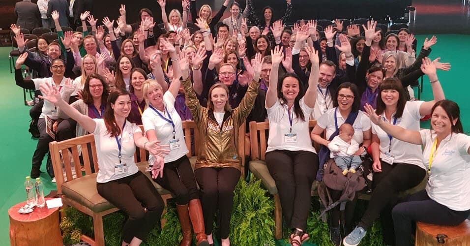 Photo: large group of SuperMums trainees waving at the camera.