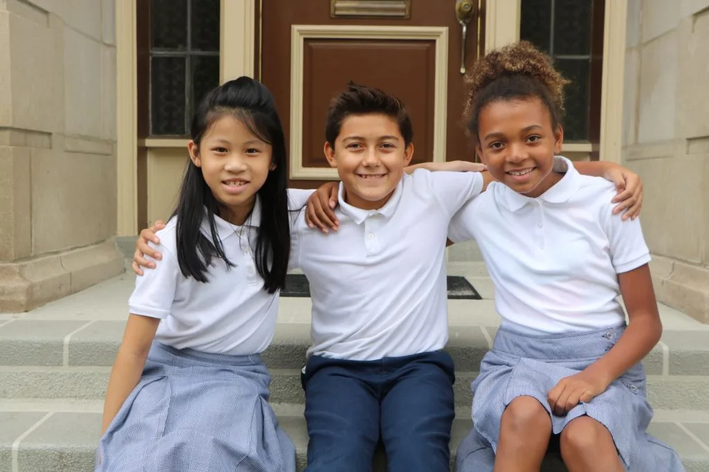 Photo: School children sitting on steps smiling