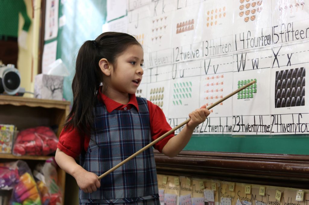 Photo: Big Shoulders Fund student points at classroom chalkboard.