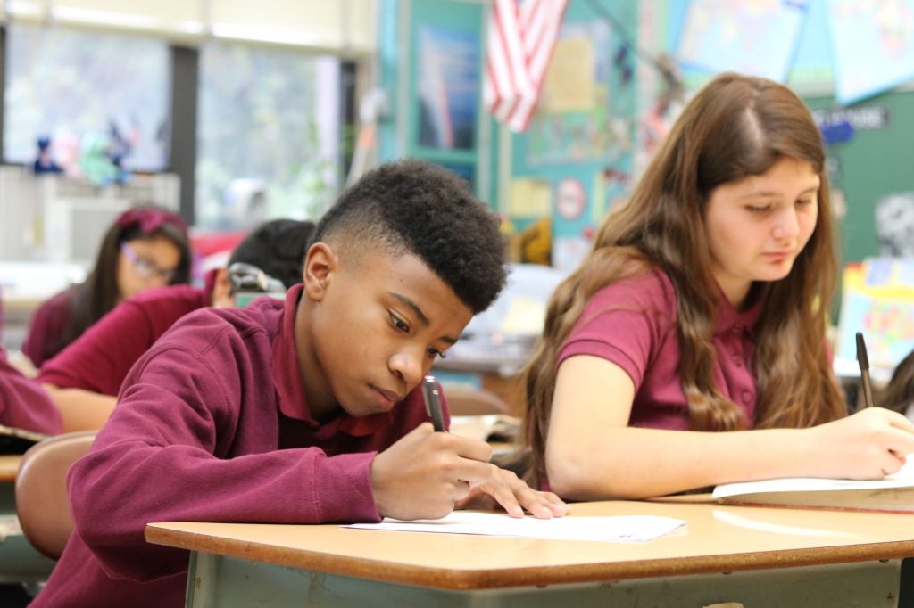 Photo: Big Shoulders Fund Children writing at classroom desk.