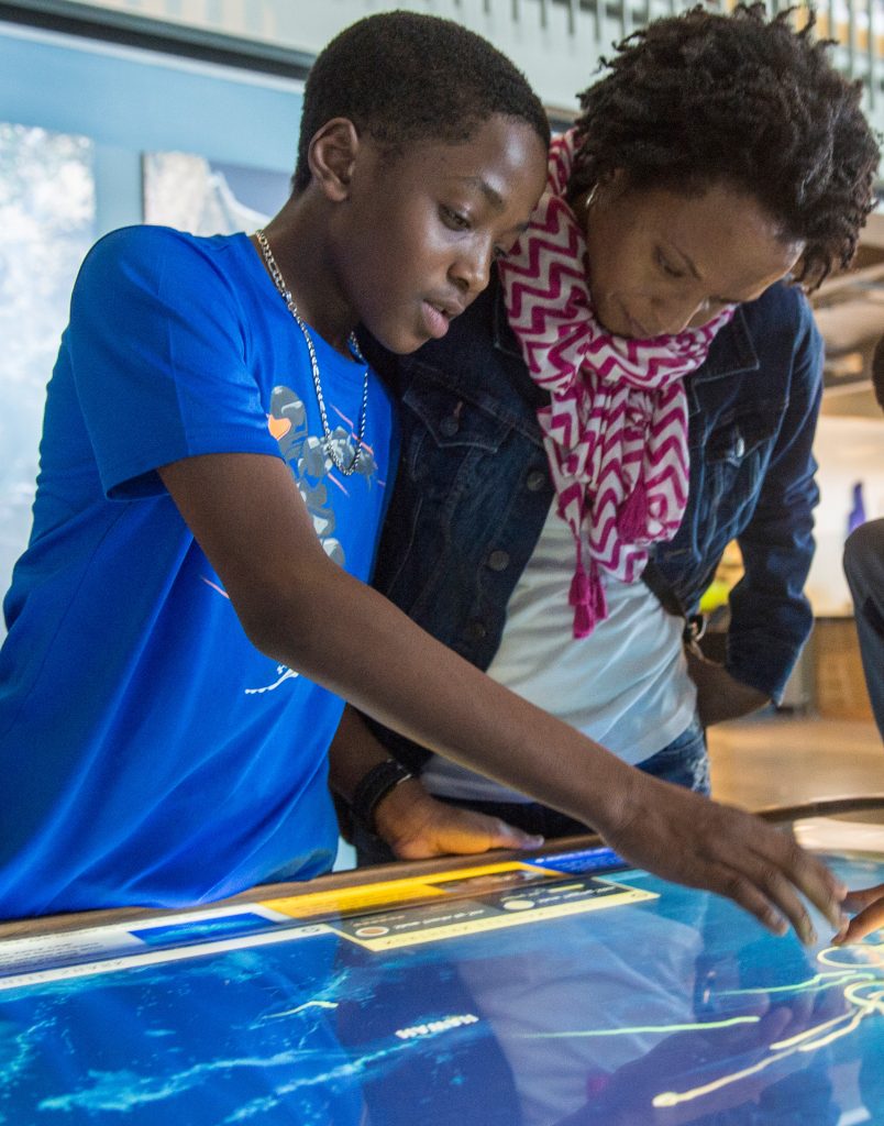 Photo: A woman and boy interact with an exhibit at the Exploratorium.