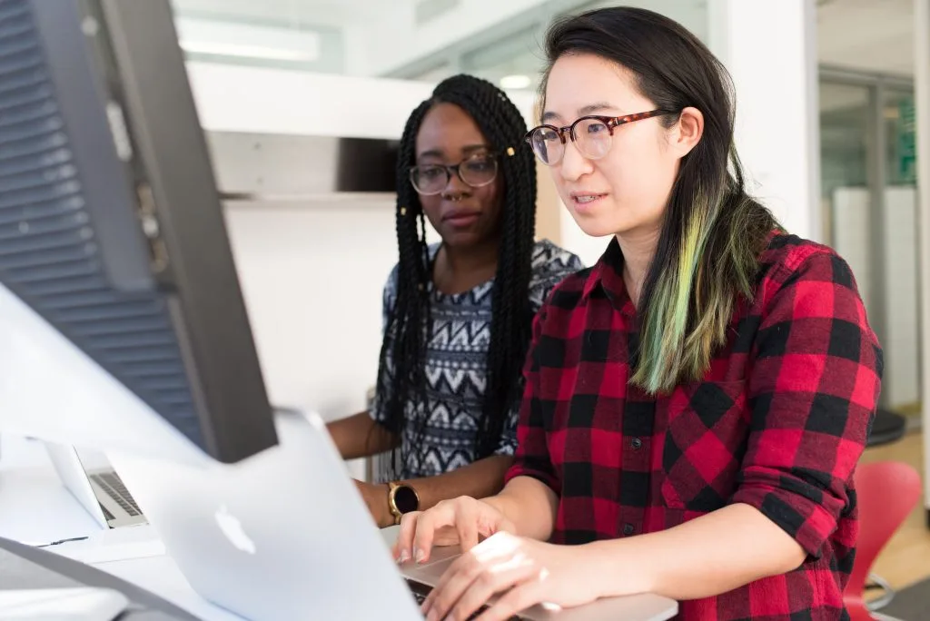 Photo of two women working together at a computer