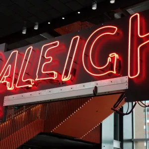 Picture of lit neon sign that says Raleigh