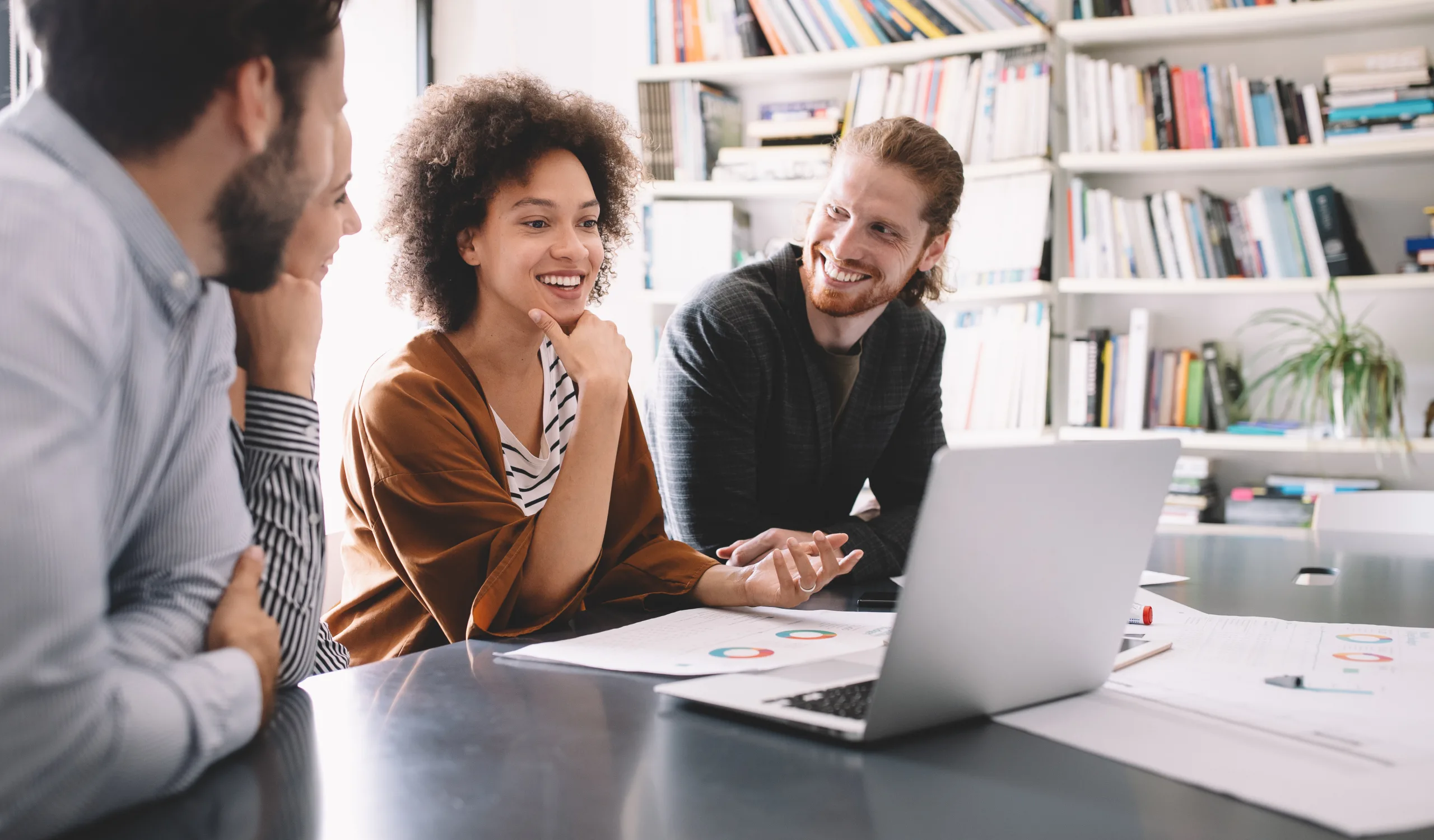 Diverse team of individuals working around a laptop computer